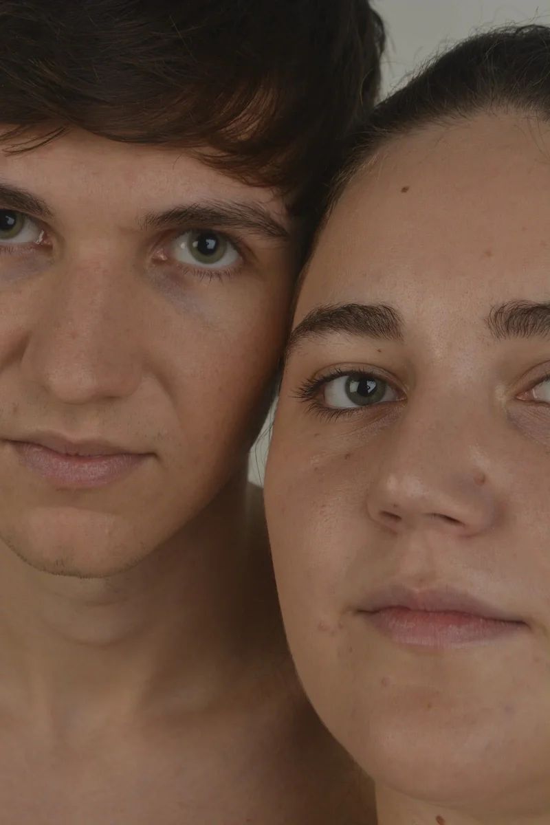 Retrato beauty de dos modelos con los rostros juntos sobre fondo gris